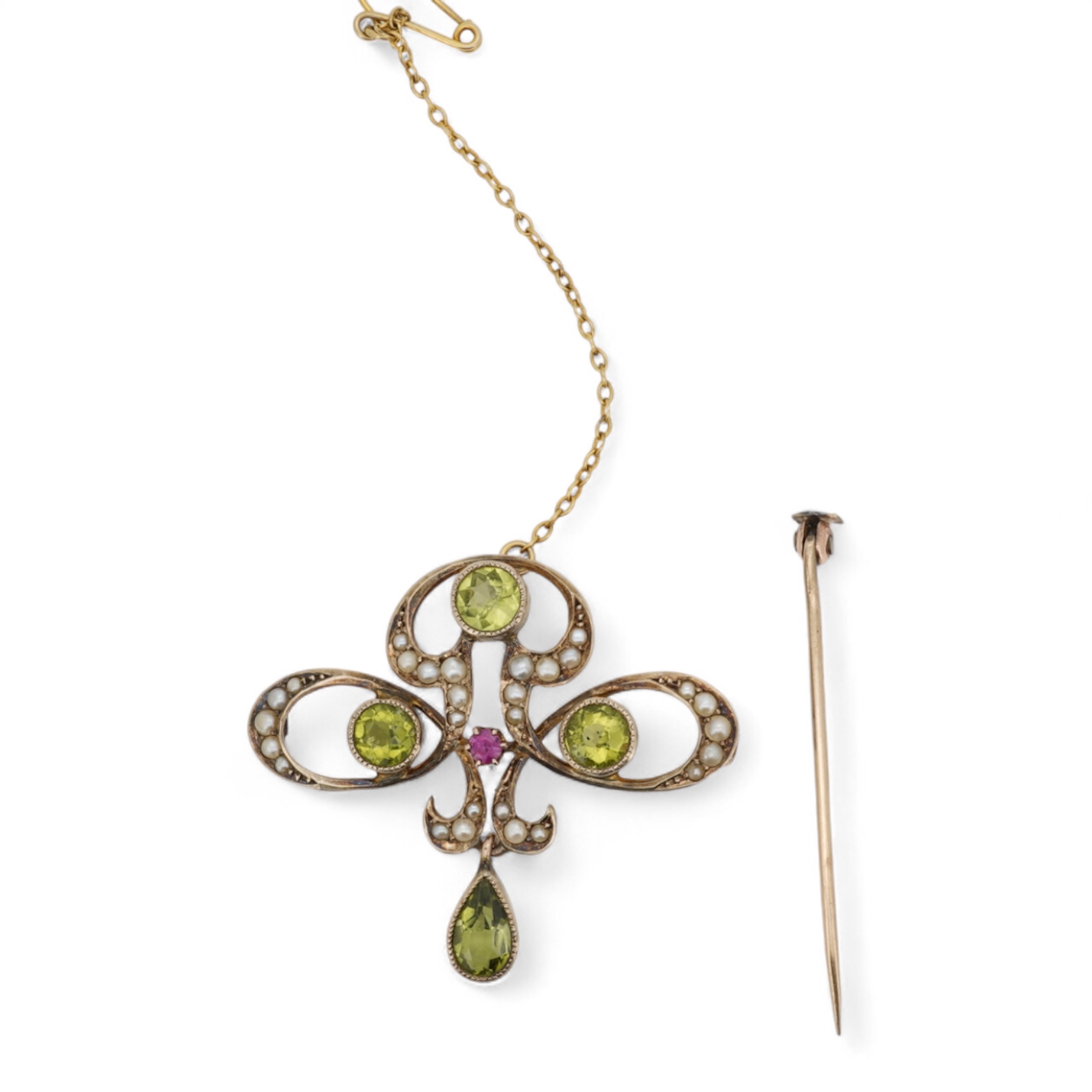 An Art Nouveau peridot, seed pearl and ruby brooch, early 20th century, of scrolled design, set with half seed pearls, circular-cut and pear-shaped peridots and a circular-cut ruby, length 3cm, gross weight approximately